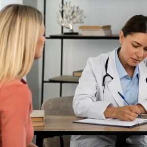 Une médecin féminine écrit des notes sur un clipboard, concentrée sur son travail.