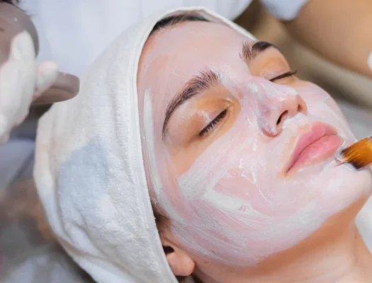 A woman receiving a facial treatment, wearing a soothing mask, in a serene spa environment.