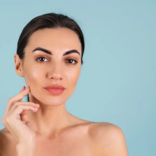 Femme belle avec des produits de soin sur le visage, mettant en avant un traitement d'injection de comblement.