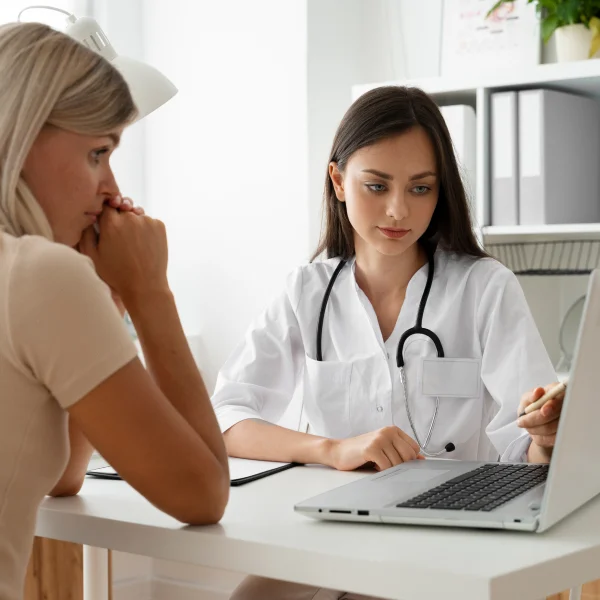 A woman sitting at a desk, preparing for a hyaluronic acid injection procedure.