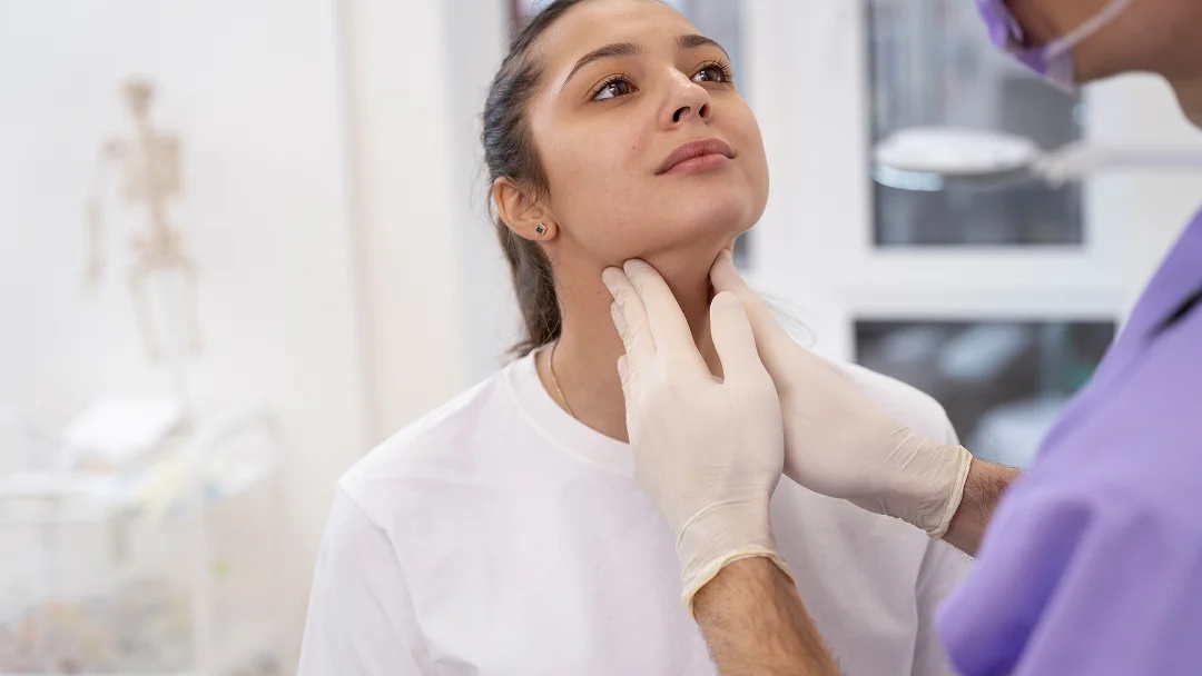 A woman receives a neck examination from a doctor, focusing on health and potential solutions for a double chin.